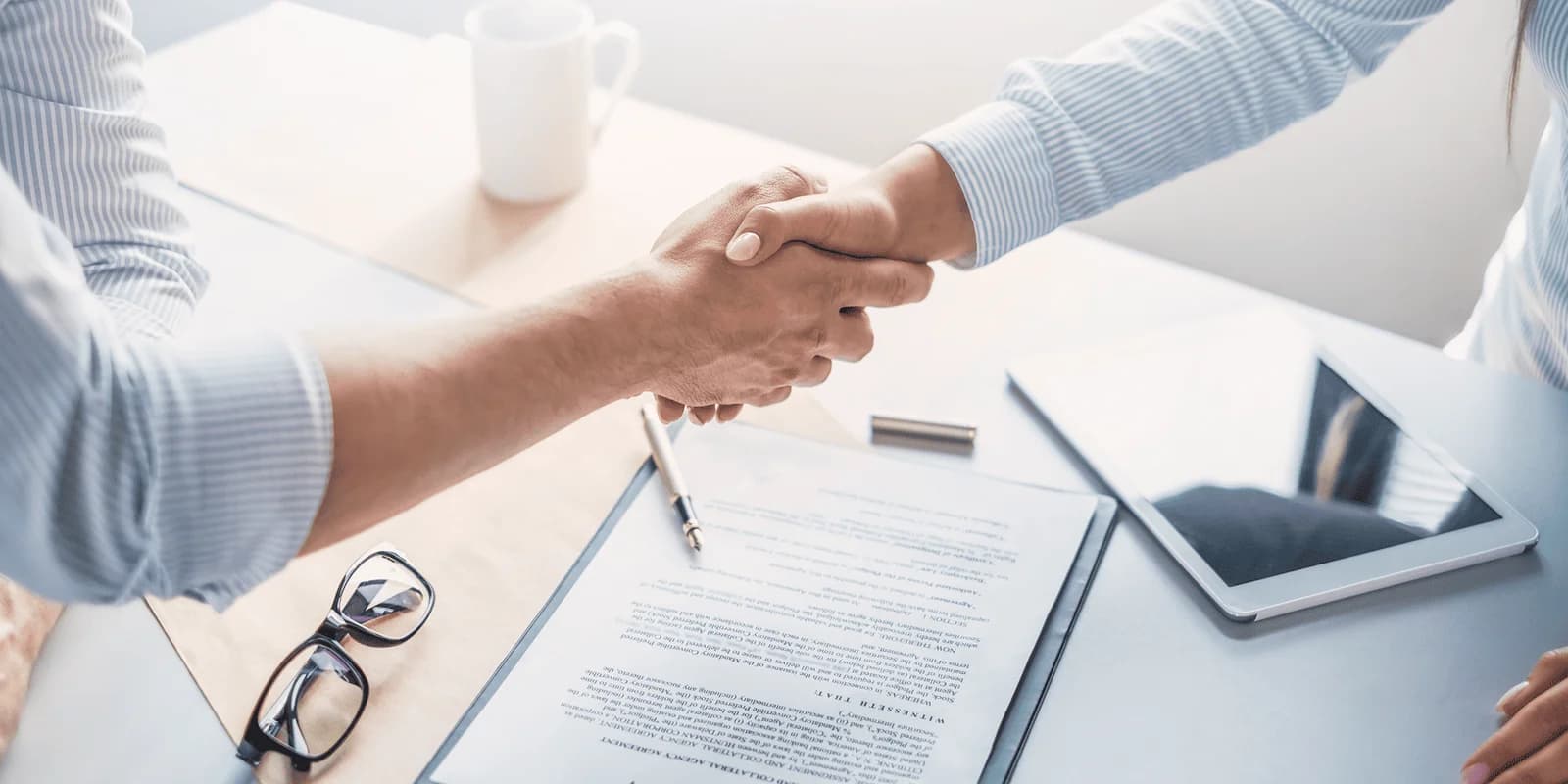 Mãos segurando um contrato e martelo de juiz, representando o Direito Civil e contratos